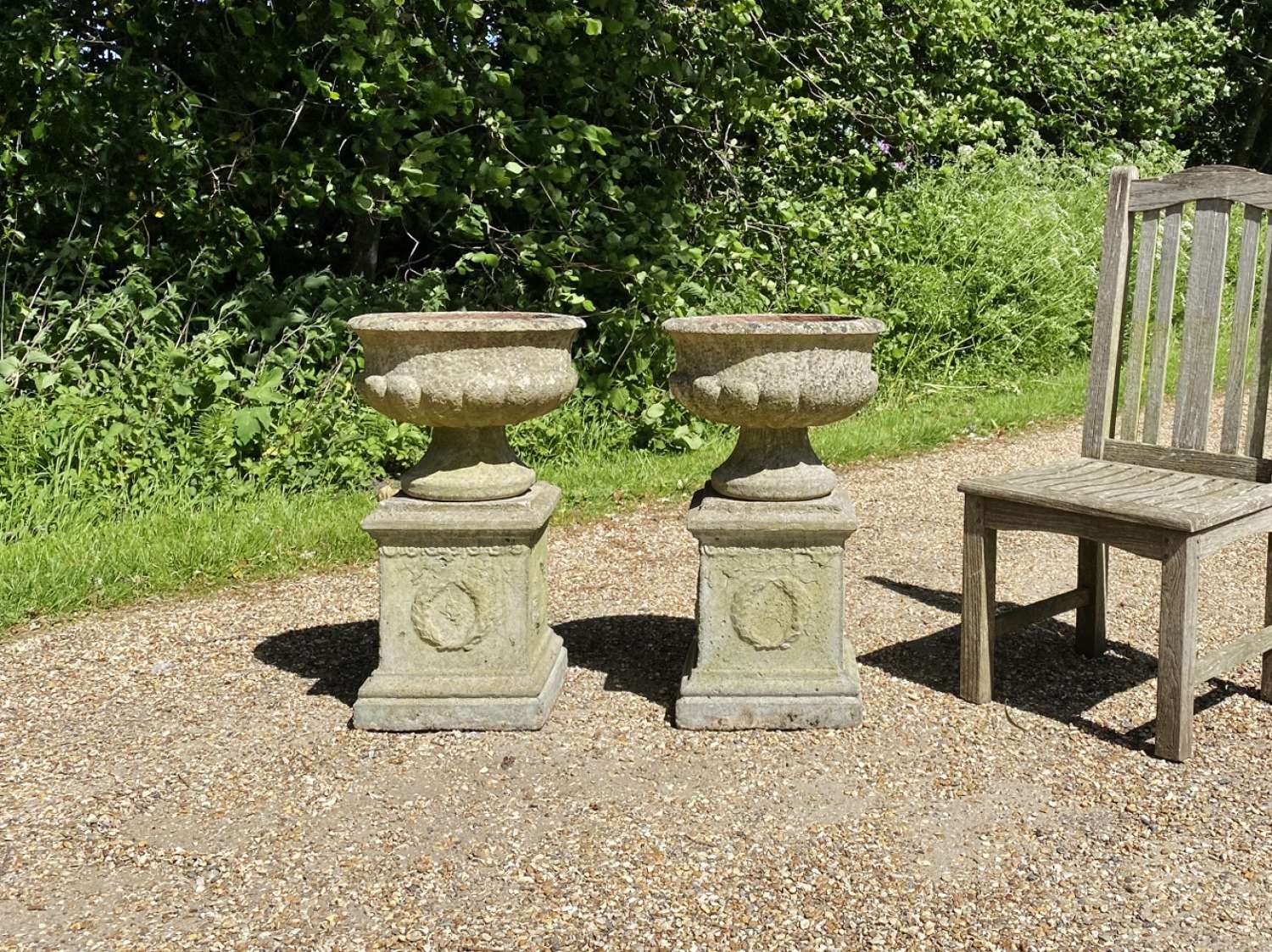 Pair of Small Patinated Urns with Pedestals