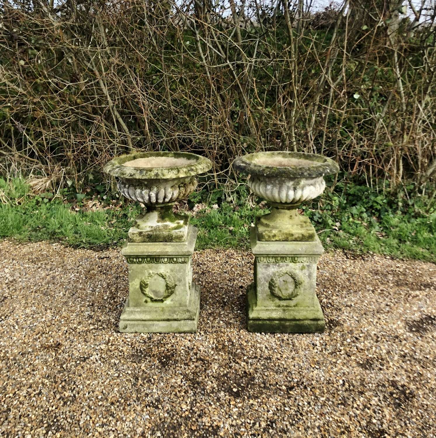 Pair of Small Patinated Urns with Pedestals